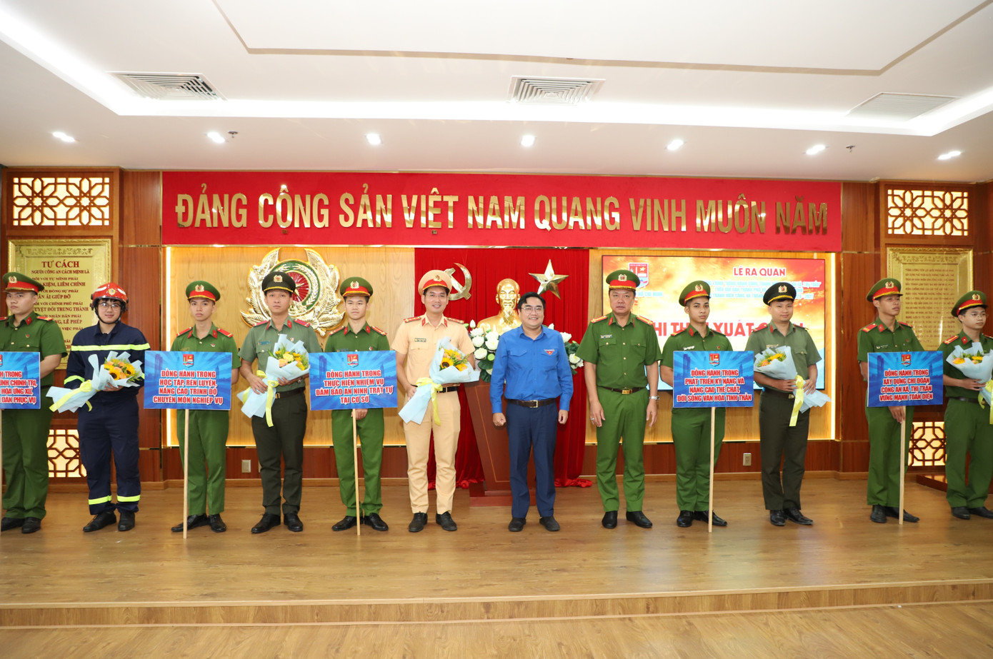 Phó Giám đốc CATP Nguyễn Đình Dương (thứ 4 từ phải qua) cùng Phó Bí thư Thường trực Thành Đoàn TPHCM Ngô Minh Hải trao hoa động viên các cán bộ, chiến sĩ tham gia đồng hành cùng lực lượng công an xã.