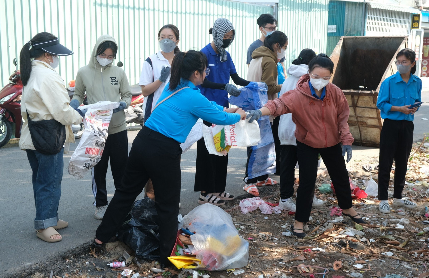Bạn trẻ huyện Nhà Bè cùng sinh viên Trường Đại học Mở ra quân làm sạch môi trường trong khu dân cư. Ảnh: Phú Quang