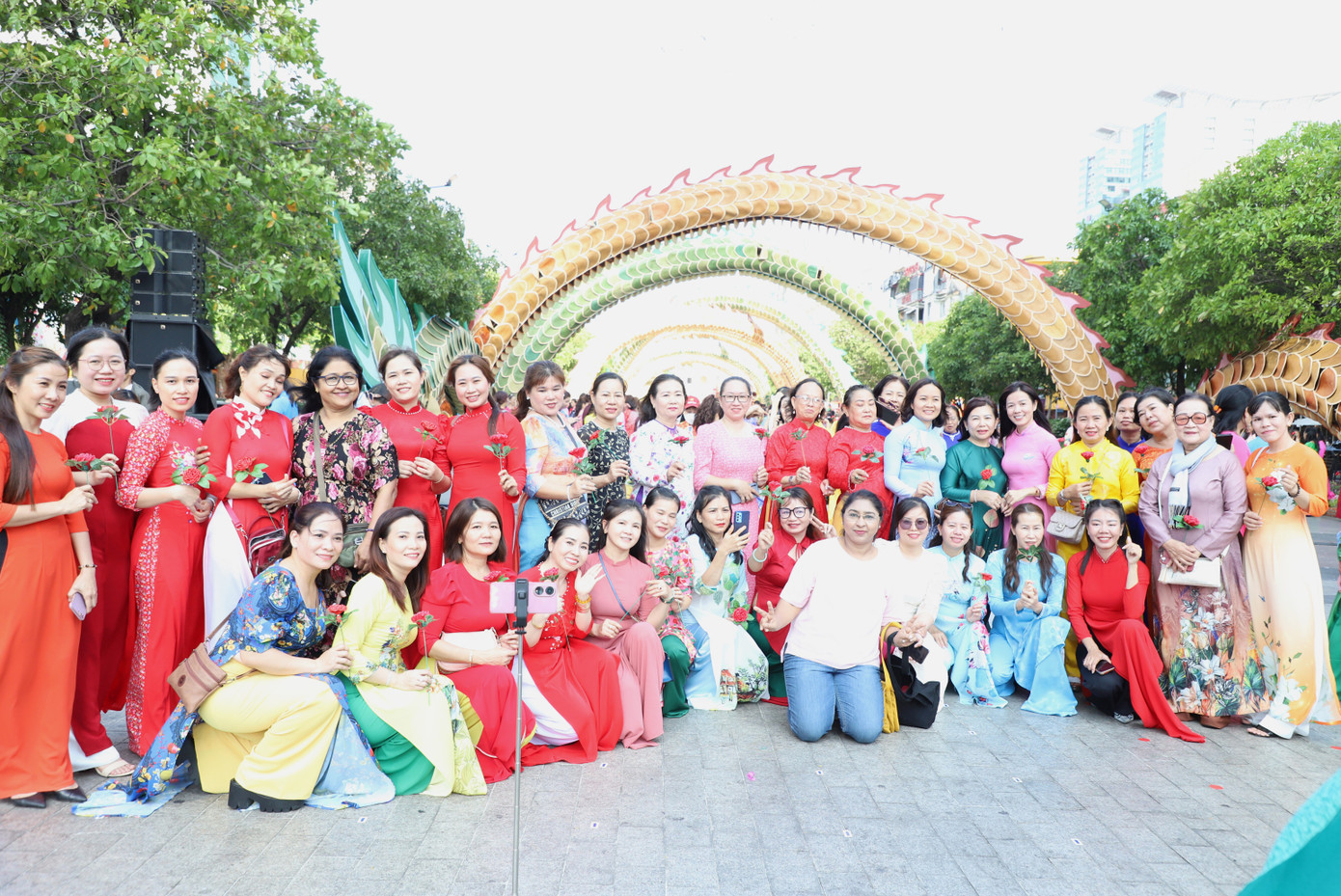 Hai nữ du khách ngoại quốc thích thú chụp ảnh với các phụ nữ Việt.