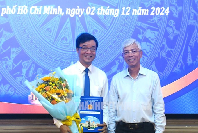 Phó Chủ tịch UBND TPHCM Võ Văn Hoan (phải) trao quyết định và chúc mừng ông Lương Văn Nhiền. Ảnh: Thành ủy TPHCM