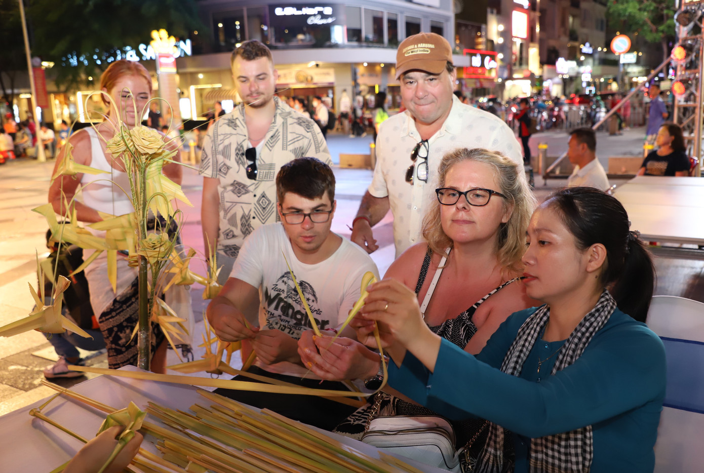 Khách nước ngoài hào hứng học xếp lá dừa nghệ thuật.