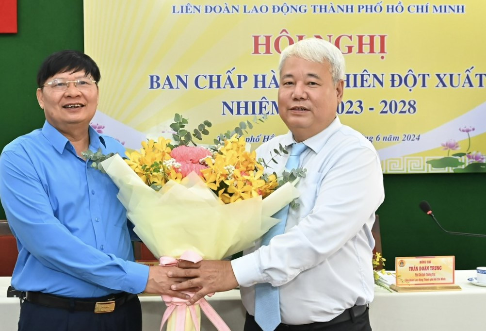 Phó Chủ tịch Tổng LĐLĐ Việt Nam Phan Văn Anh (trái) tặng hoa chúc mừng ông Võ Khắc Thái được bầu làm Chủ tịch LĐLĐ TPHCM. Ảnh: SGGP