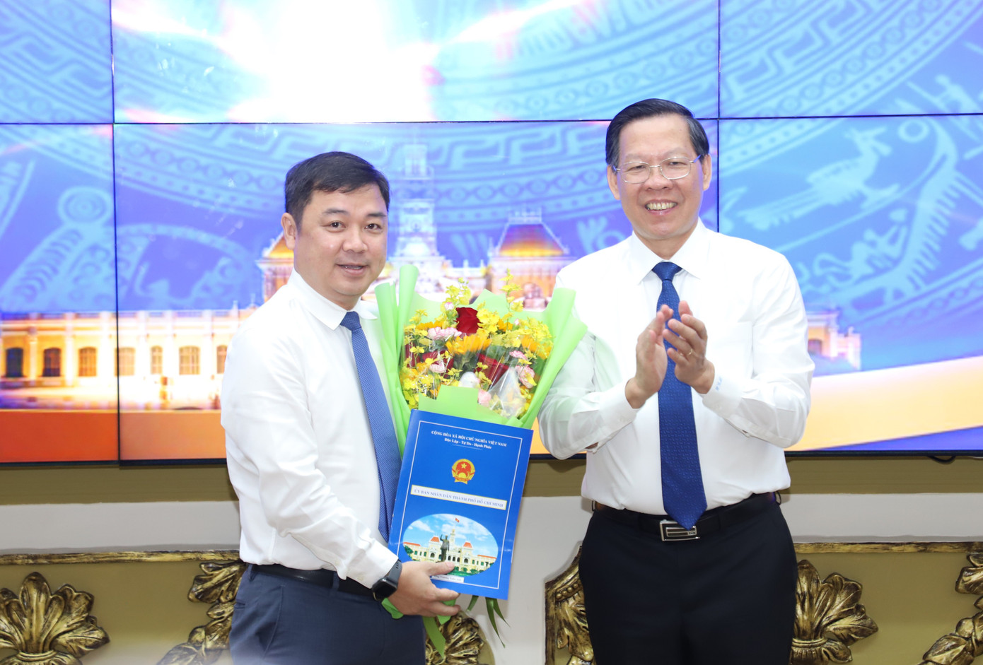 Chủ tịch UBND TPHCM Phan Văn Mãi trao quyết định và hoa chúc mừng ông Trương Tuấn Anh. Ảnh: Ngô Tùng