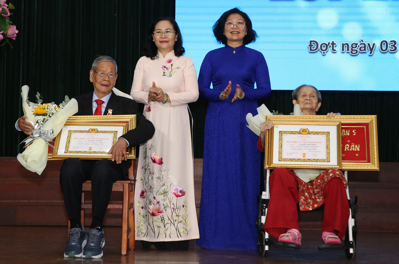 Chủ tịch HĐND TPHCM Nguyễn Thị Lệ và Bí thư Quận ủy quận 5 Huỳnh Ngọc Nữ Phương Hồng (thứ hai từ phải qua) trao huy hiệu cao quý đến các đảng viên cao tuổi Đảng.