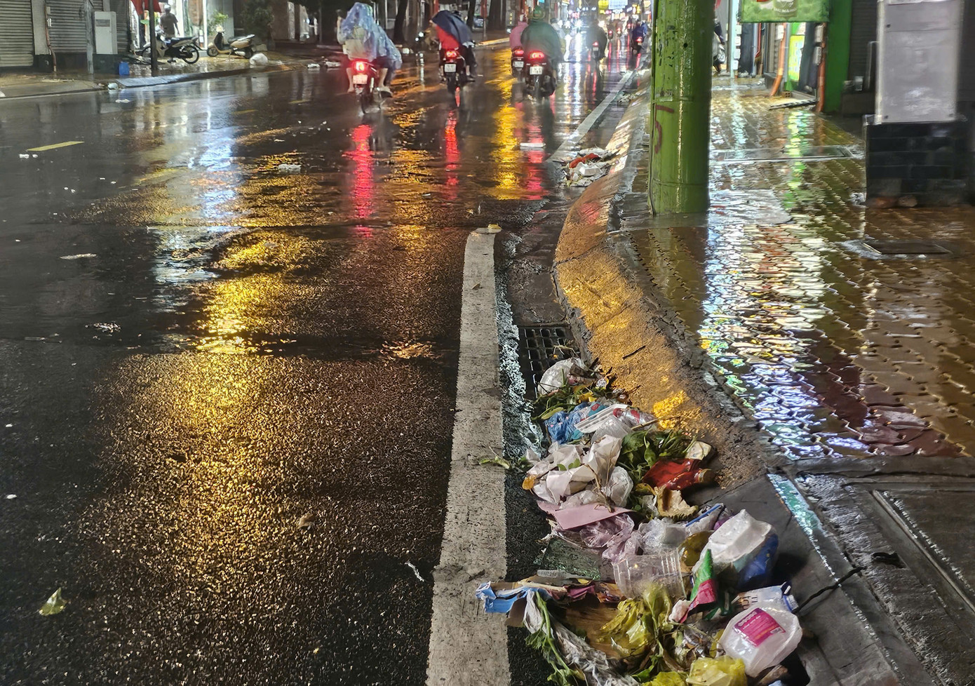 Sau cơn mưa to, rác thải chèn lấp nhiều miệng cống trên tuyến đường Võ Văn Ngân (TP. Thủ Đức).