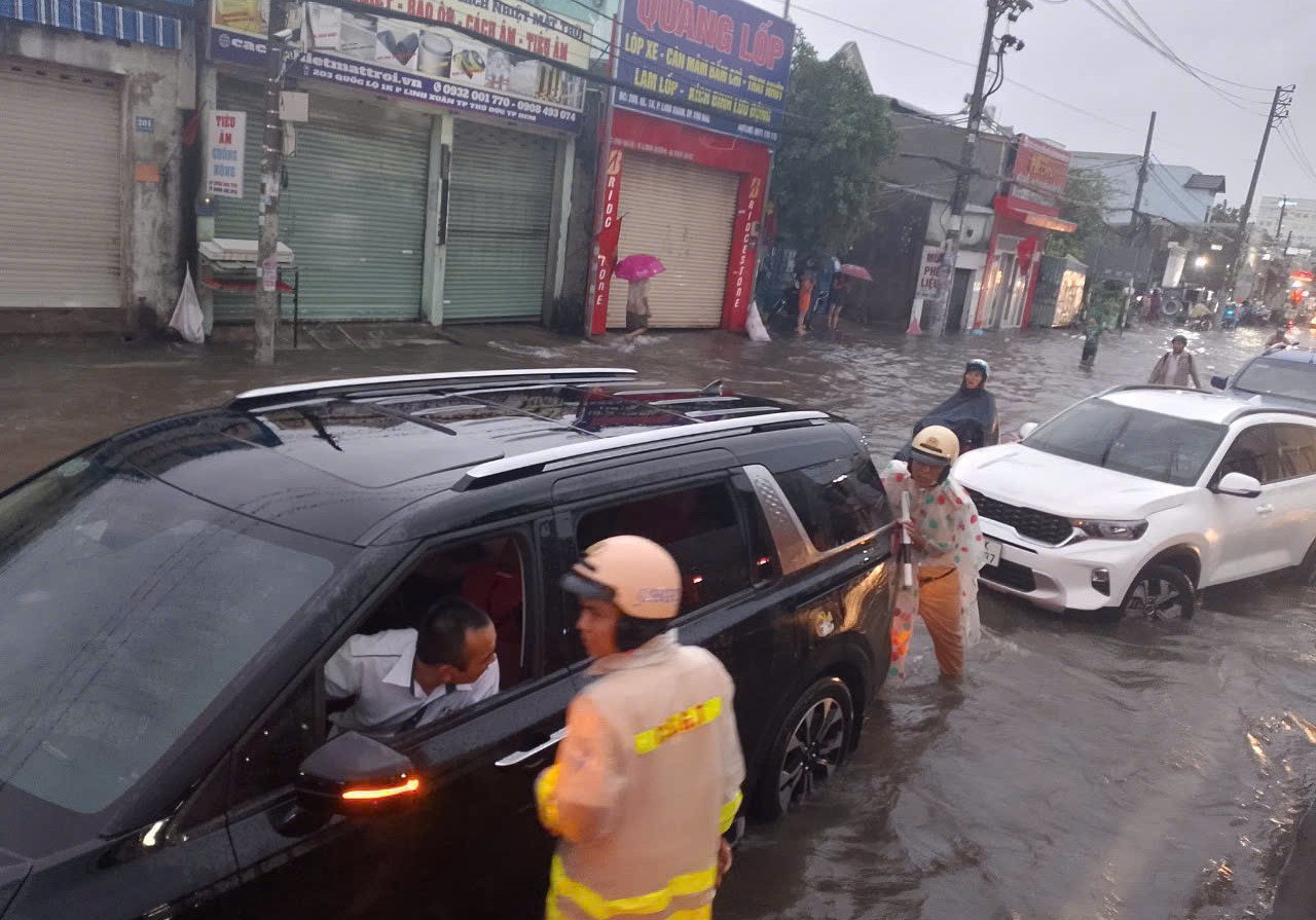 Chiều cùng ngày, mưa to gây ngập nặng trên Quốc lộ 1K và Quốc lộ 1 đoạn từ vòng xoay Bình Phước về cầu vượt Gò Dưa (TP. Thủ Đức), Đội CSGT Bình Triệu thuộc Phòng CSGT Công an TPHCM điều động cán bộ, chiến sĩ tăng cường điều tiết giao thông và giải cứu ô tô chết máy, hỗ trợ người dân.