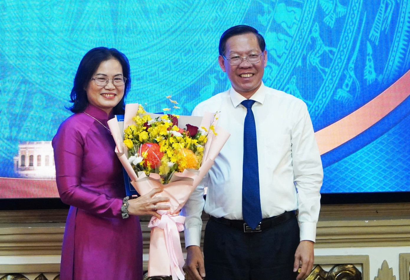 Chủ tịch UBND TPHCM Phan Văn Mãi trao quyết định và hoa chúc mừng bà Nguyễn Thị Hồng Hạnh. Ảnh: CTV