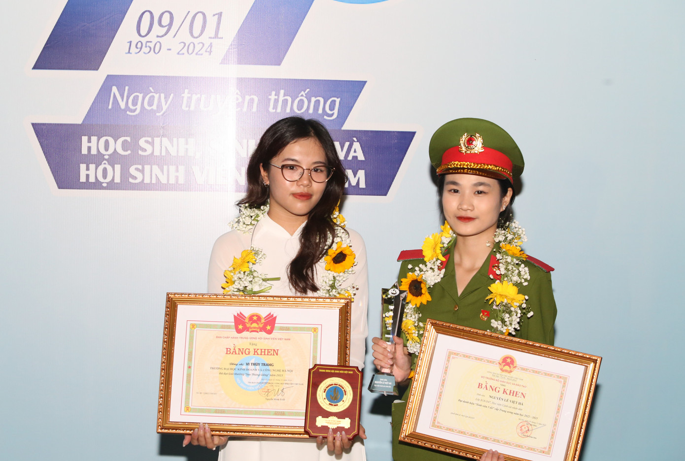 Nữ sinh Vi Thùy Trang (bên trái, Trường Đại học Kinh doanh và Công nghệ Hà Nội) cùng bạn Nguyễn Lê Việt Hà (Học viện Cảnh sát nhân dân) đón nhận danh hiệu "Sao tháng Giêng" và "Sinh viên 5 tốt".