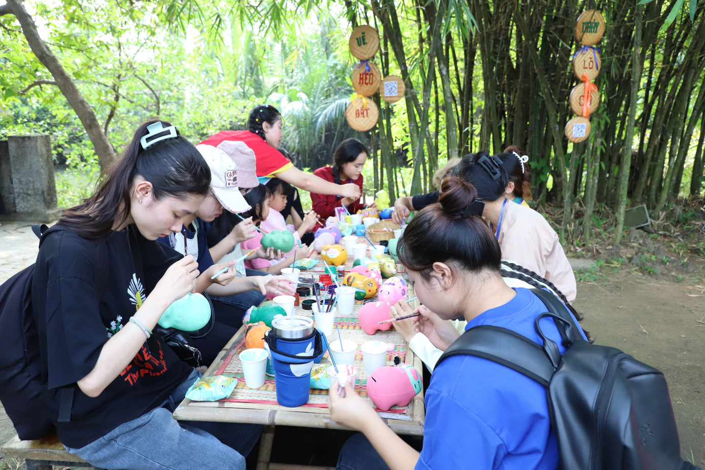 Ở một góc khác, mỗi người chăm chút tô vẽ màu sắc cho những chú heo đất theo ý thích và phong cách của riêng mình.