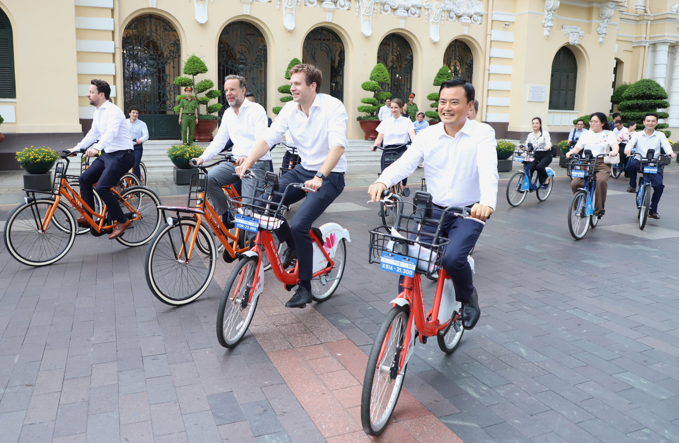 Lãnh đạo hai thành phố cùng các đại biểu đạp xe trên đường phố TPHCM sau buổi làm việc. Ảnh: Ngô Tùng