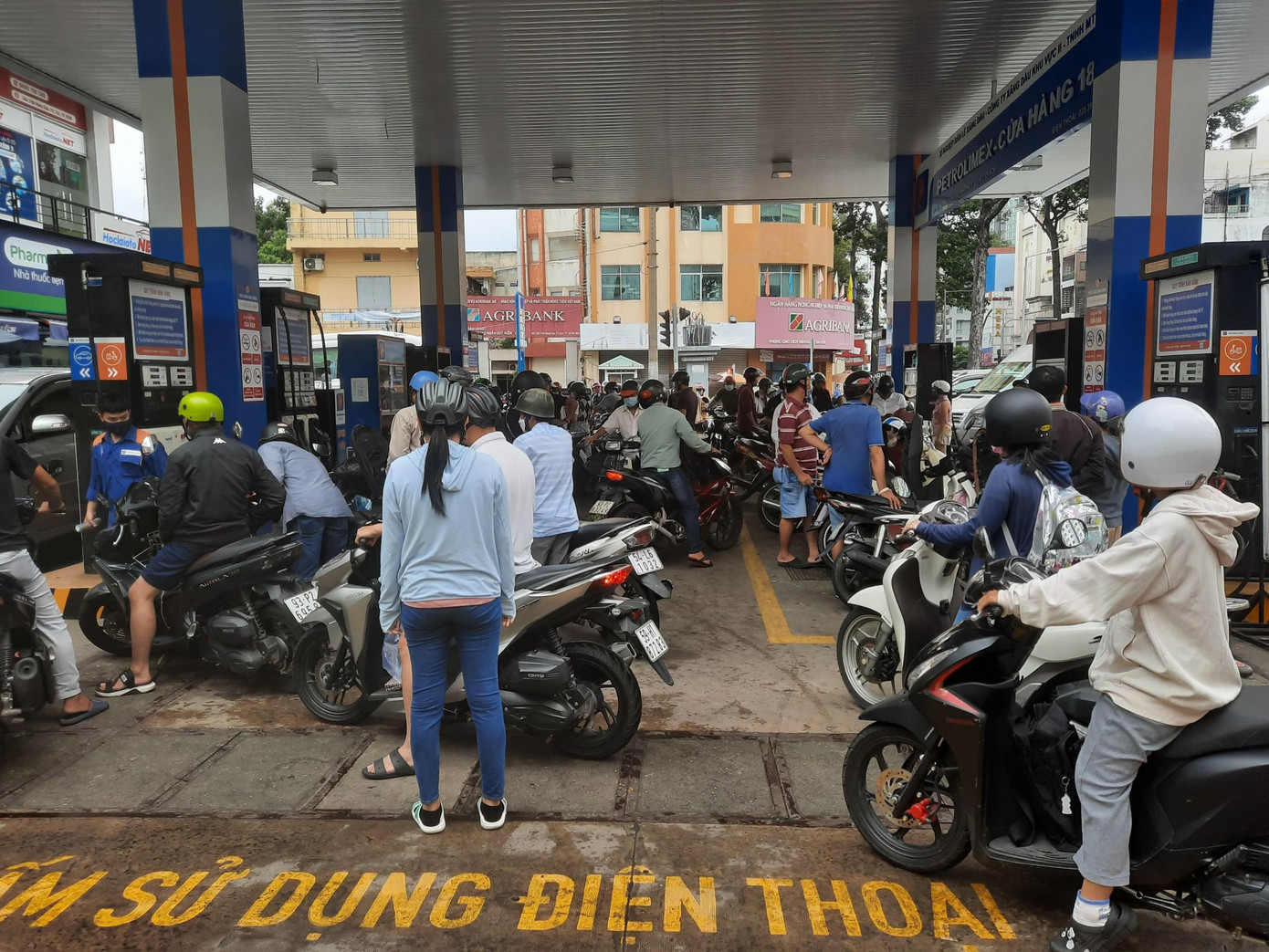 Tại Cửa hàng xăng dầu Petrolimex - cửa hàng số 18 (địa chỉ 444 Trần Hưng Đạo, quận 5, TPHCM) khách nườm nượp đến và xếp hàng dài chờ đổ xăng từ sáng sớm. Bà Mai (ngụ quận 8, một trong những người phải xếp hàng chờ đổ xăng) cho biết: &quot;Xe tôi gần như đã cạn xăng, không thể di chuyển qua các điểm khác được nữa, đành phải chờ hơn 15 phút mới đổ được một ít&quot;.