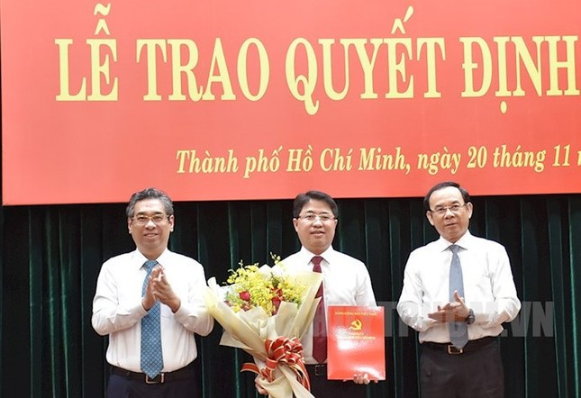 Bí thư Thành ủy TPHCM Nguyễn Văn Nên (bìa phải) và Phó Bí thư Thành ủy TPHCM Nguyễn Phước Lộc trao quyết định bổ nhiệm và hoa chúc mừng ông Phạm Hồng Sơn. Ảnh: Thành ủy TPHCM