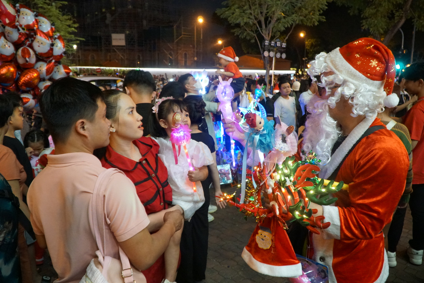 Tận dụng dịp đông người tới vui chơi, nhiều người hoá trang thành Ông già Noel bán mũ, cài đầu, bong bóng cho trẻ em.