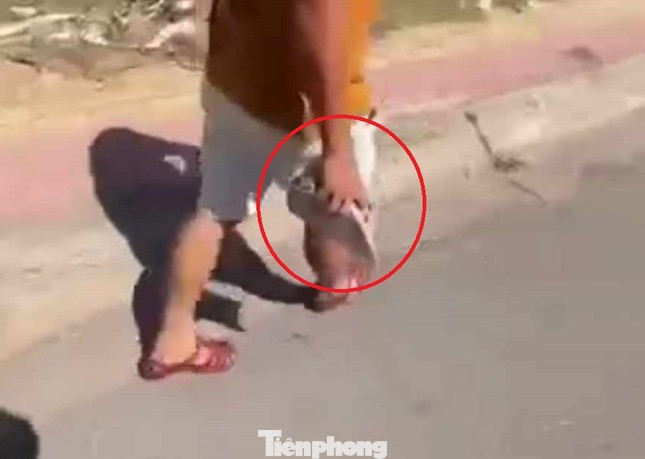 Cán bộ CSGT có hành vi cầm viên gạch dọa đánh một người dân. Ảnh cắt từ clip Cán bộ CSGT có hành vi cầm viên gạch dọa đánh một người dân. Ảnh cắt từ clip