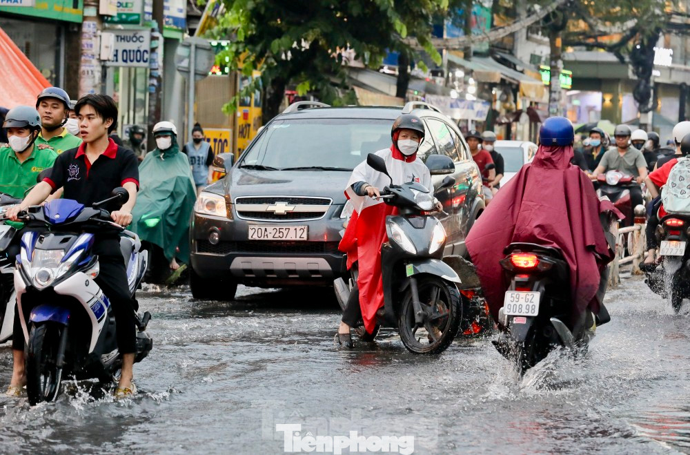 Người dân di chuyển trong cơn mưa lớn tại TPHCM. Ảnh: Duy Anh.