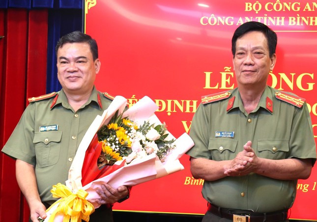 Đại tá Nguyễn Văn Dựt - Phó Giám đốc Công an tỉnh Bình Dương, tặng hoa chúc mừng Thượng tá Võ Thành Trung (bìa trái)