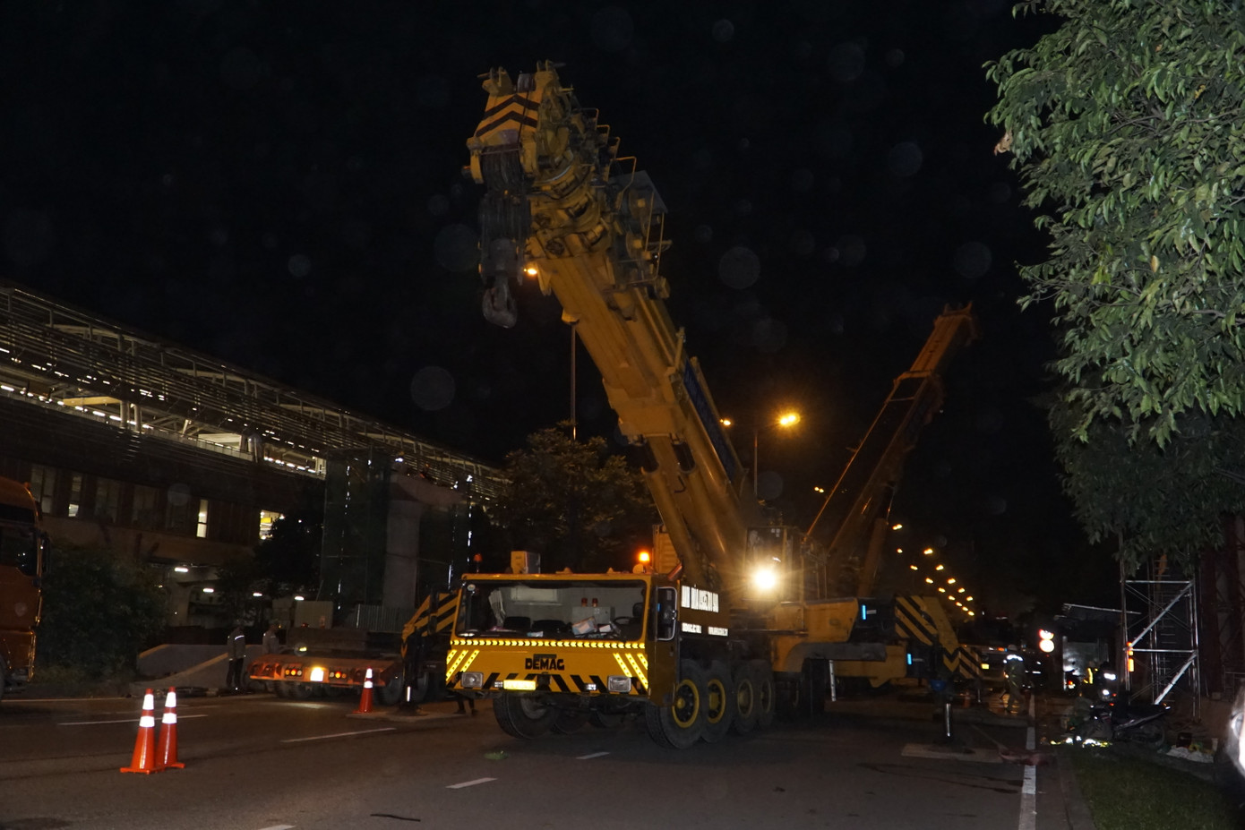 Các công nhân làm việc xuyên đêm để hoàn thành việc lắp dầm cầu.