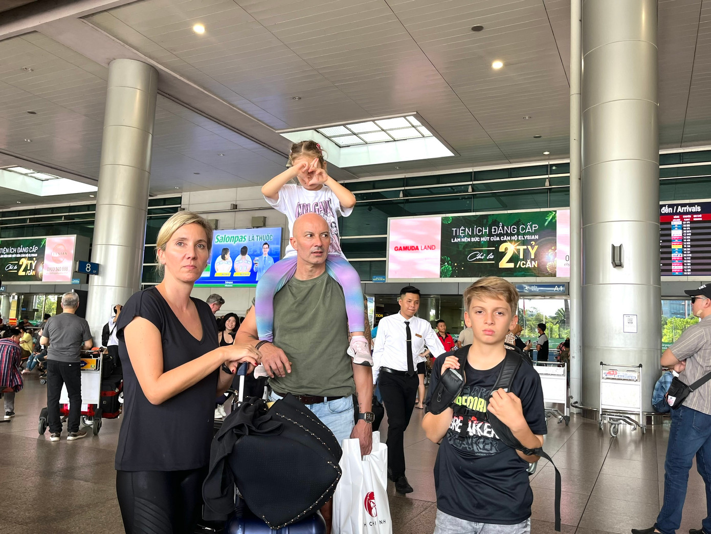 Với lượng lớn hành lý, nhiều du khách vất vả di chuyển, đặt xe trong thời tiết nắng nóng tại TPHCM.