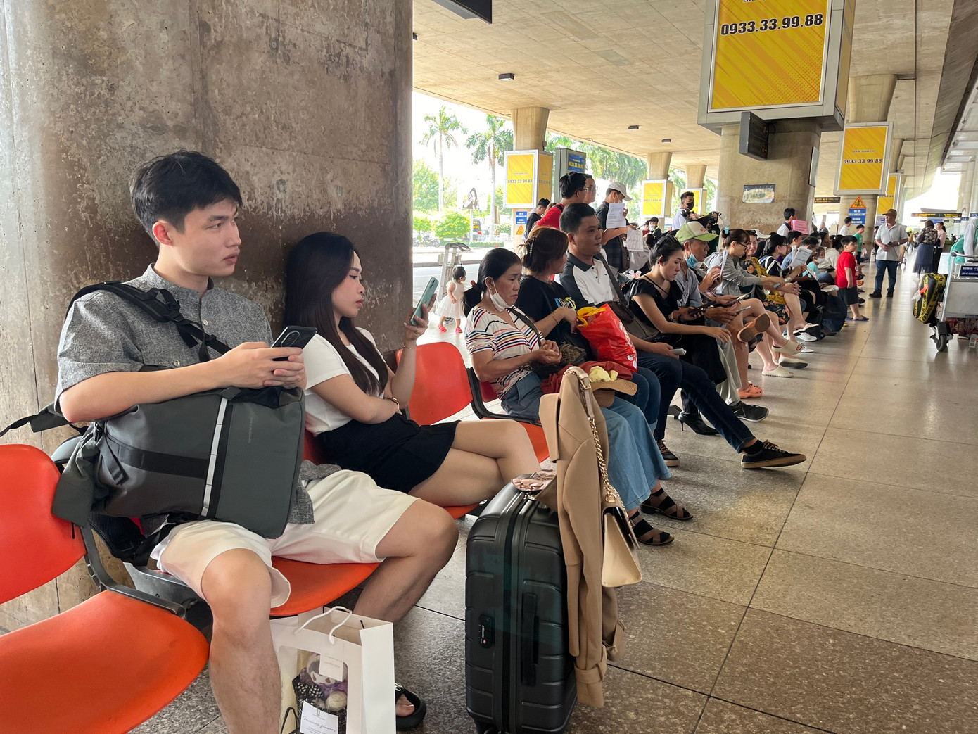 Một số khách Việt Nam chờ đợi người thân đến đón sau chuyến bay dài.