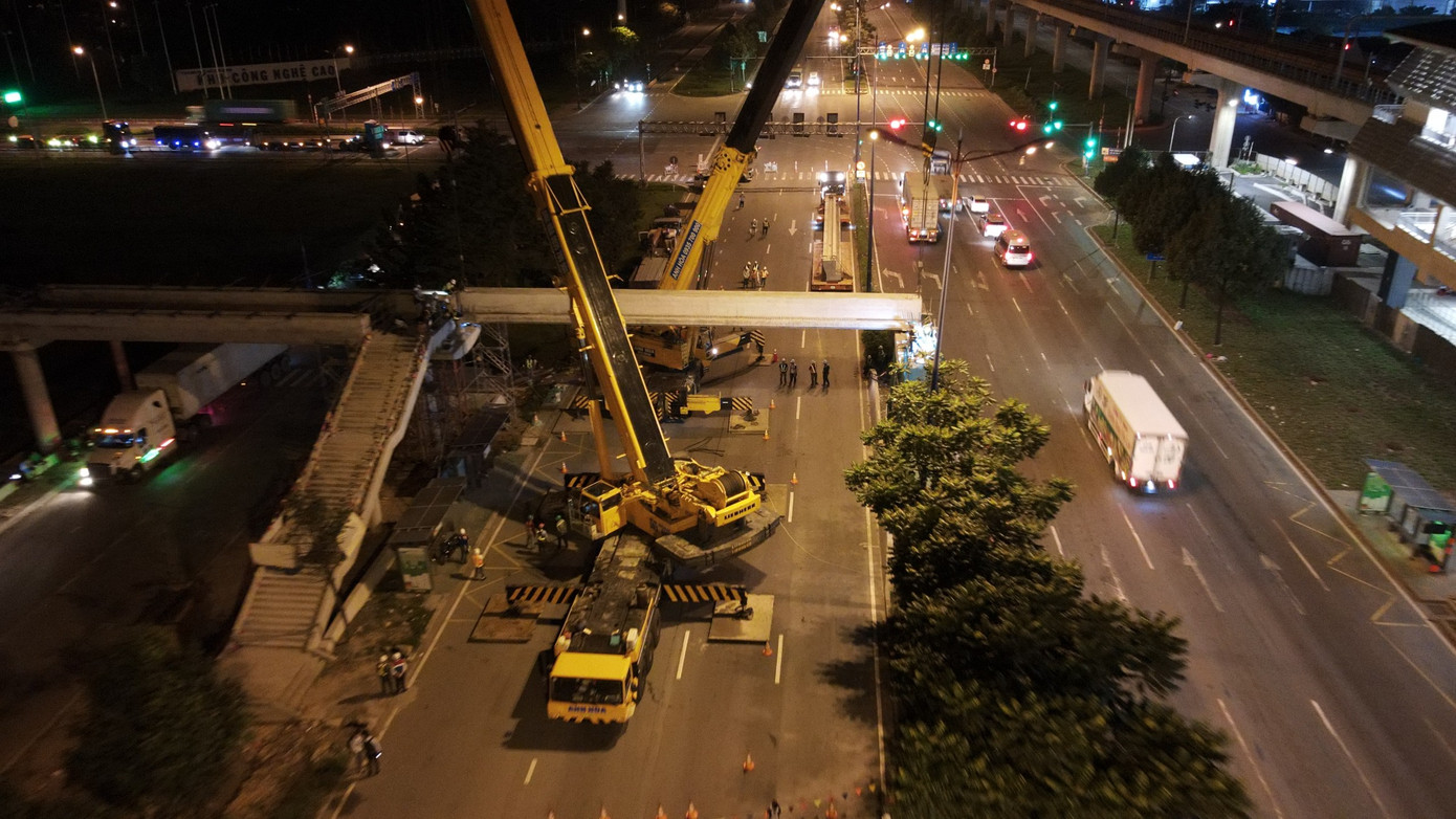 Toàn cảnh công tác lắp đặt dầm cầu bộ hành nhìn từ trên cao.