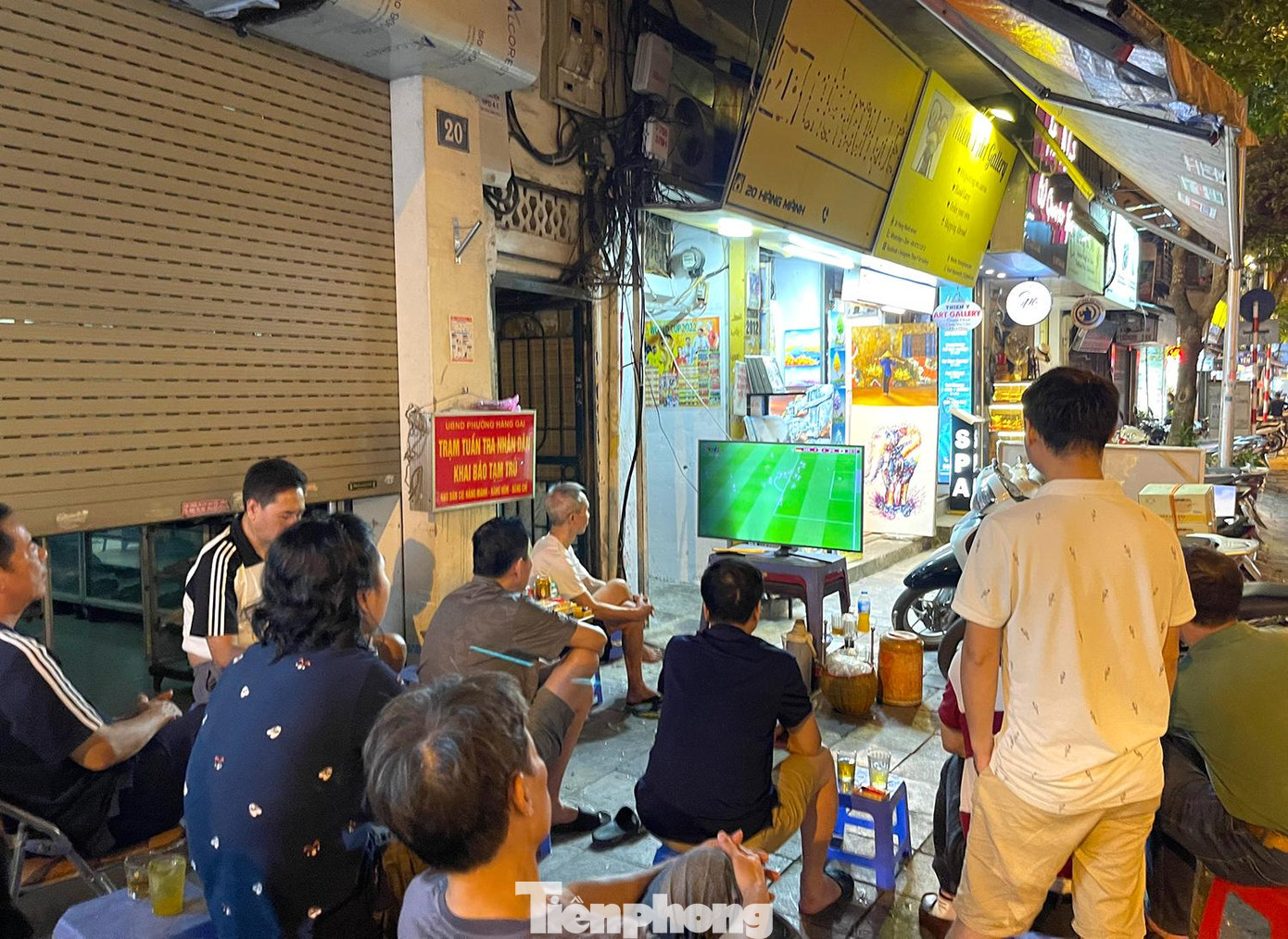 Trên phố Hàng Mành một quán trà đá cũng trưng dụng tivi ra vỉa hè cho người dân cùng xem chung