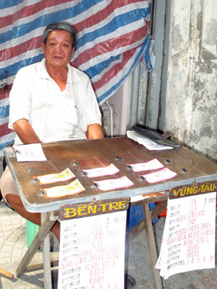 Ông Lê Đình Thi bên bàn vé số trên đường Cống Quỳnh trưa 2-1-2013 . Ảnh: N.K Ông Lê Đình Thi bên bàn vé số trên đường Cống Quỳnh trưa 2-1-2013