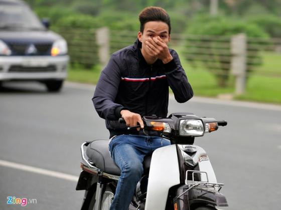 Nam thanh niên không đội mũ bảo hiểm vội vàng che mặt khi bị chụp ảnh đi vào làn ôtô với tốc độ cao.