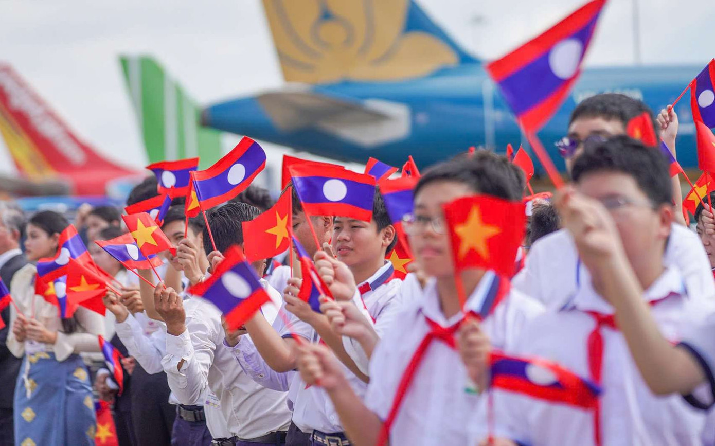 Học sinh Việt Nam và Lào trong lễ tiễn Tổng Bí thư, Chủ tịch nước Lào Thongloun Sisoulith và Phu nhân tại sân bay Quốc tế Tân Sơn Nhất.