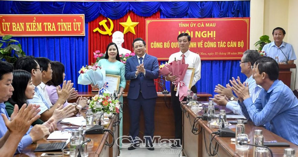 Đồng chí Nguyễn Đức Hiển, Phó bí thư Tỉnh uỷ trao quyết định, tặng hoa chúc mừng đồng chí Bùi Thị Minh và đồng chí Phạm Minh Xuân. Ảnh: Báo Cà Mau