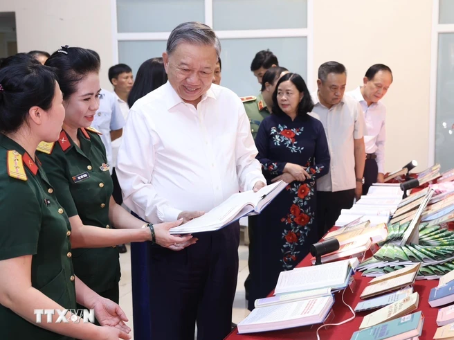 Chủ tịch nước Tô Lâm xem các ấn phẩm, tài liệu tuyên truyền bảo vệ an ninh Tổ quốc tại phường Cửa Đông. (Ảnh: Lâm Khánh/TTXVN)