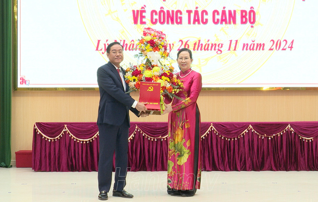 Bà Lê Thị Thủy, Ủy viên Trung ương Đảng, Bí thư Tỉnh ủy, Chủ tịch HĐND tỉnh trao quyết định, tặng hoa chúc mừng ông Trần Văn Thuấn.