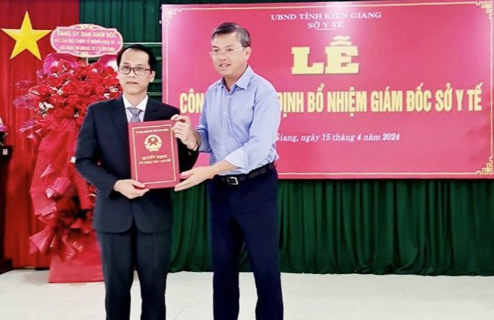 Phó Chủ tịch UBND tỉnh Kiên Giang Nguyễn Lưu Trung (bên phải) trao quyết định cho Đại tá Hồ Văn Dũng.