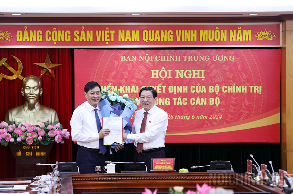 Ông Phan Đình Trạc, Trưởng Ban Nội chính Trung ương trao quyết định và tặng hoa chúc mừng ông Nguyễn Hữu Đông. Ảnh: Báo Chính phủ