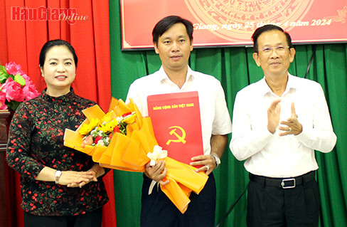 Ông Nguyễn Thiện Nhơn (bìa phải), Ủy viên Ban Thường vụ, Trưởng Ban Tổ chức Tỉnh ủy và bà Phạm Thị Phượng, Ủy viên Ban Thường vụ, Chủ nhiệm Ủy ban Kiểm tra Tỉnh ủy, trao quyết định và tặng hoa chúc mừng ông Tăng Minh Nghĩa. Ảnh: Báo Hậu Giang