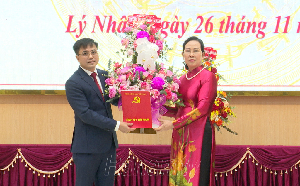 Bà Lê Thị Thủy, Ủy viên Trung ương Đảng, Bí thư Tỉnh ủy, Chủ tịch HĐND tỉnh trao quyết định, tặng hoa chúc mừng ông Bùi Văn Hoàng.