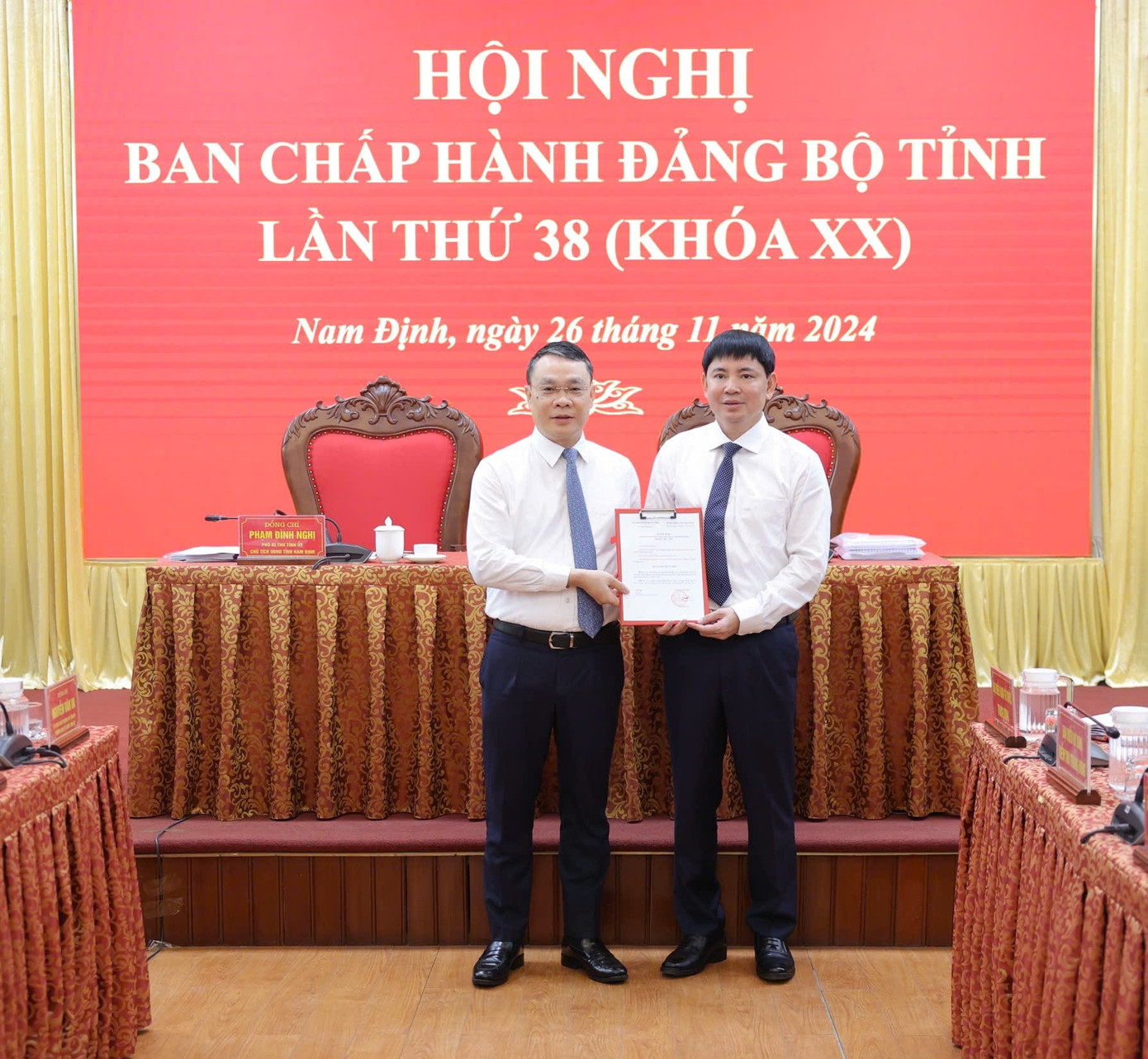 Bí thư Tỉnh ủy Nam Định Đặng Khánh Toàn trao quyết định của Ban Bí thư Trung ương Đảng, tặng hoa chúc mừng ông Nguyễn Hoàng Anh, Ủy viên BCH Đảng bộ tỉnh, Trưởng Ban quản lý các Khu công nghiệp tỉnh. Ảnh: Báo Đại đoàn kết