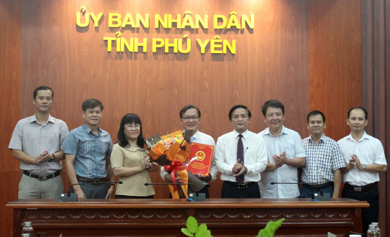 Ông Dương Bá Toàn nhận quyết định và hoa chúc mừng của lãnh đạo UBND tỉnh.