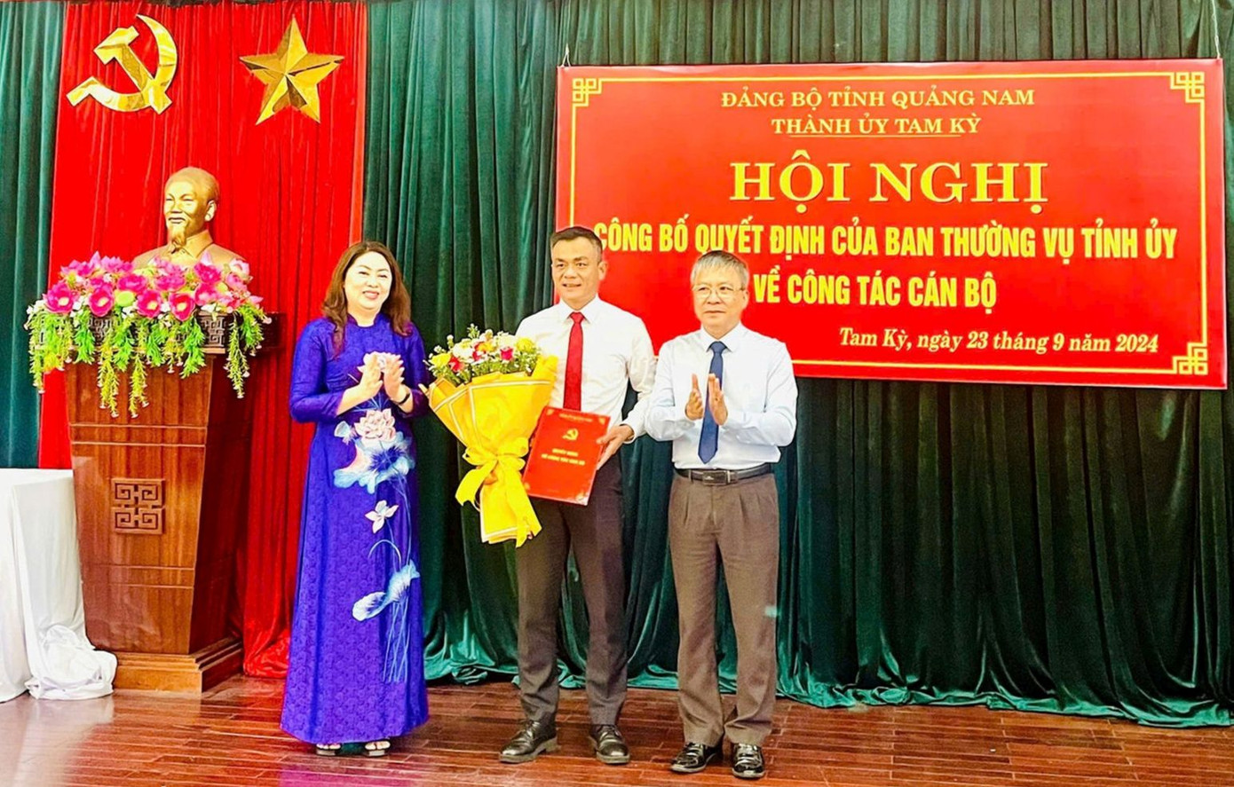 Phó Bí thư Thường trực Tỉnh ủy Nguyễn Đức Dũng và Bí thư Thành ủy Tam Kỳ Nguyễn Thị Thu Lan trao quyết định, tặng hoa chúc mừng ông Phạm Hoàng Đức. Ảnh: Báo Quảng Nam