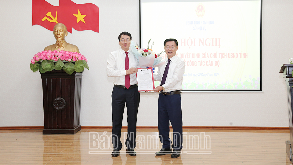 Chủ tịch UBND tỉnh Nam Định Phạm Đình Nghị trao quyết định và tặng hoa chúc mừng tân Giám đốc Sở Nội vụ Phạm Quang Ái. Ảnh: Báo Nam Định