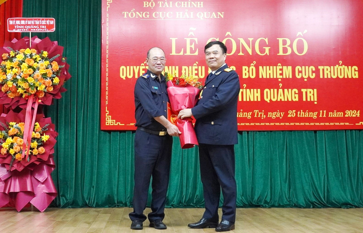 Tổng Cục trưởng Tổng Cục Hải quan Nguyễn Văn Thọ (bên phải) trao quyết định và tặng hoa chúc mừng ông Chu Quang Hải