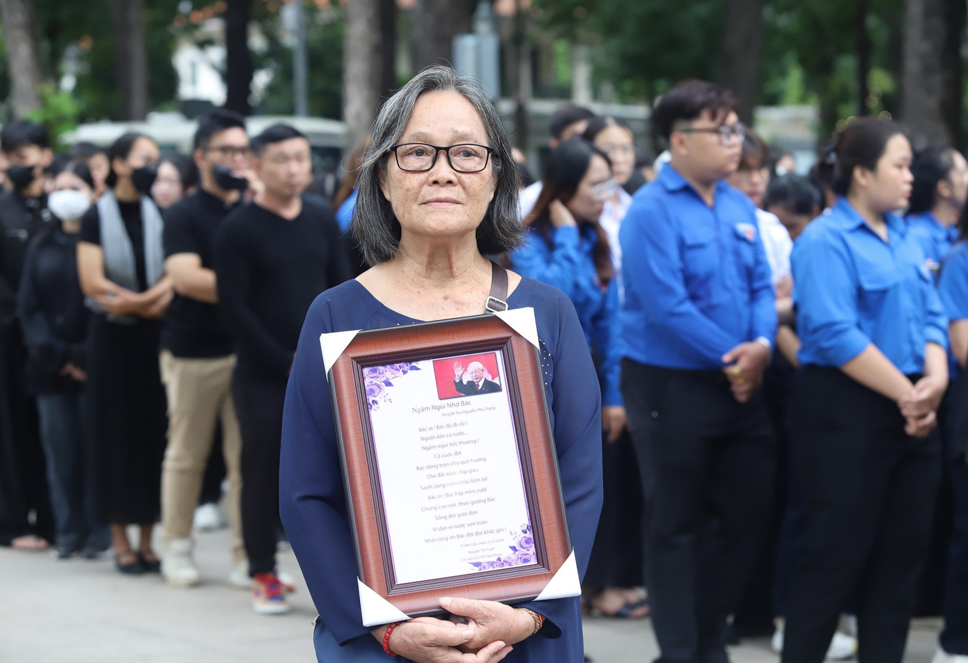 Ôm trên tay khung ảnh có hình Tổng Bí thư Nguyễn Phú Trọng cùng bài thơ do mình sáng tác, bà Nguyễn Thị Tuyết (66 tuổi, ngụ TP Bến Cát, tỉnh Bình Dương) cho biết, bà xuất phát từ nhà vào lúc 3h30 và có mặt tại Hội trường Thống Nhất lúc 5h để chờ vào viếng Tổng Bí thư.