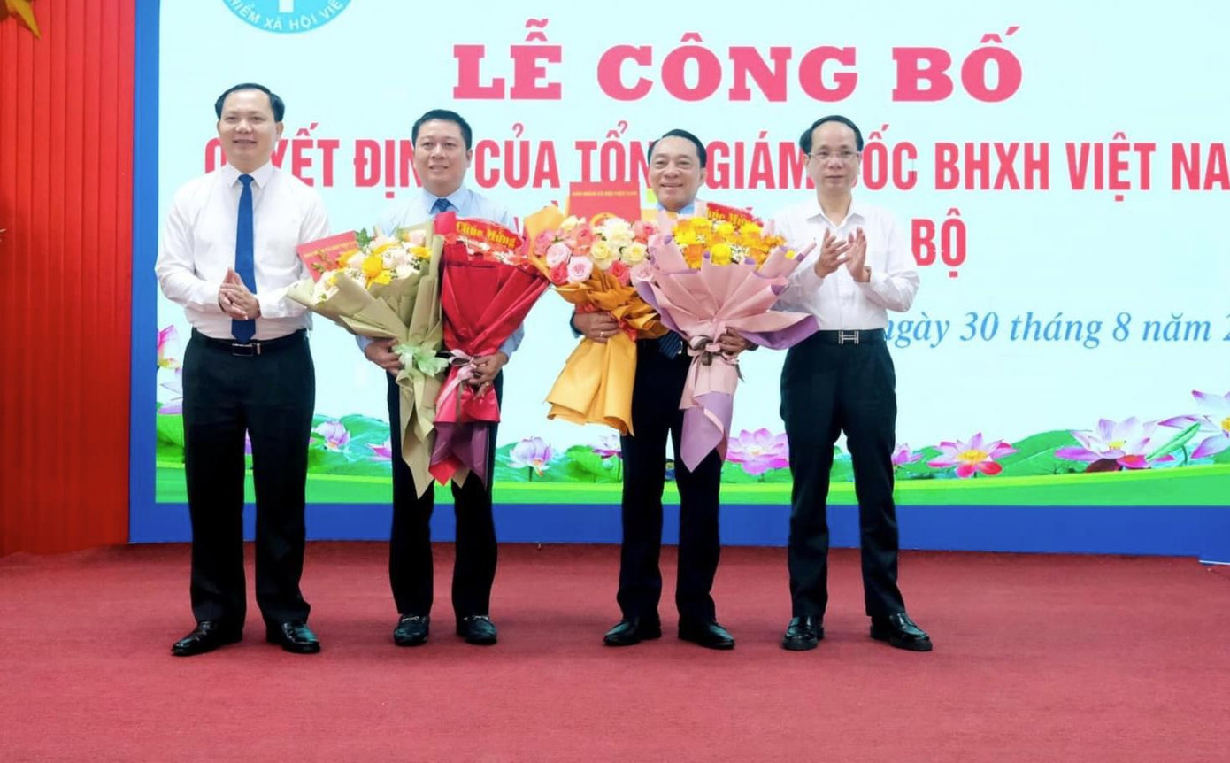 Lãnh đạo BHXH Việt Nam và lãnh đạo tỉnh Quảng Bình tặng hoa chúc mừng ông Trần Anh Tuấn và ông Phạm Thanh Tùng.