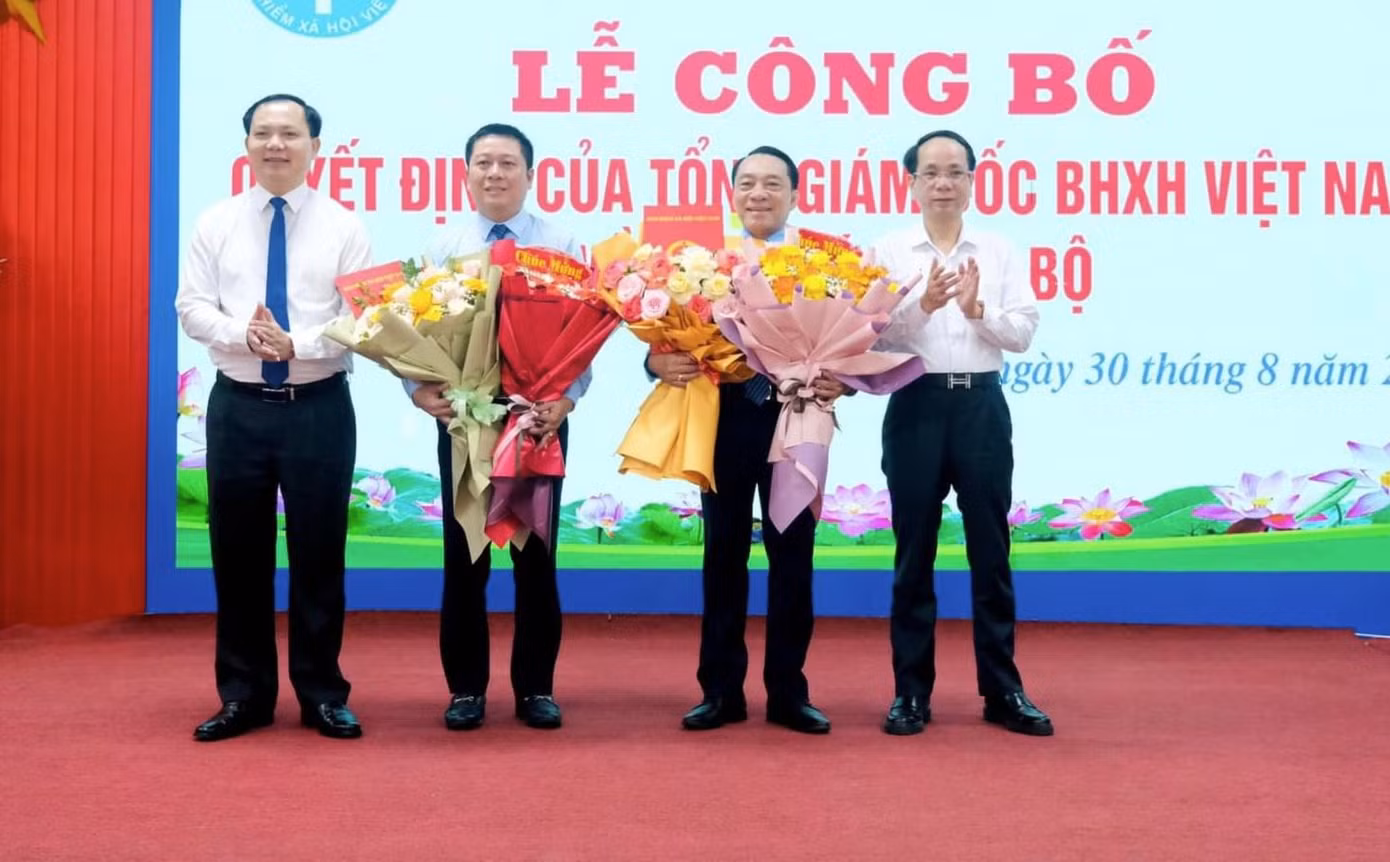 Lãnh đạo BHXH Việt Nam và lãnh đạo tỉnh Quảng Bình tặng hoa chúc mừng ông Trần Anh Tuấn và ông Phạm Thanh Tùng.