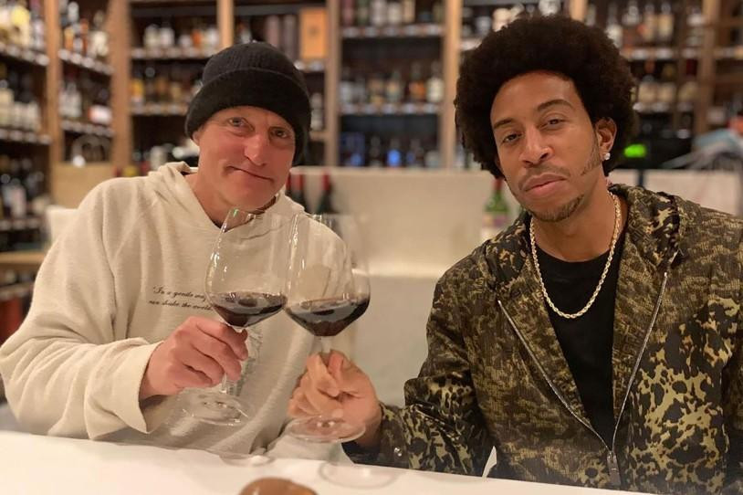 Tài tử Woody Harrelson (trái) và rapper Ludacris cùng thưởng thức rượu vang trong nhà hàng.