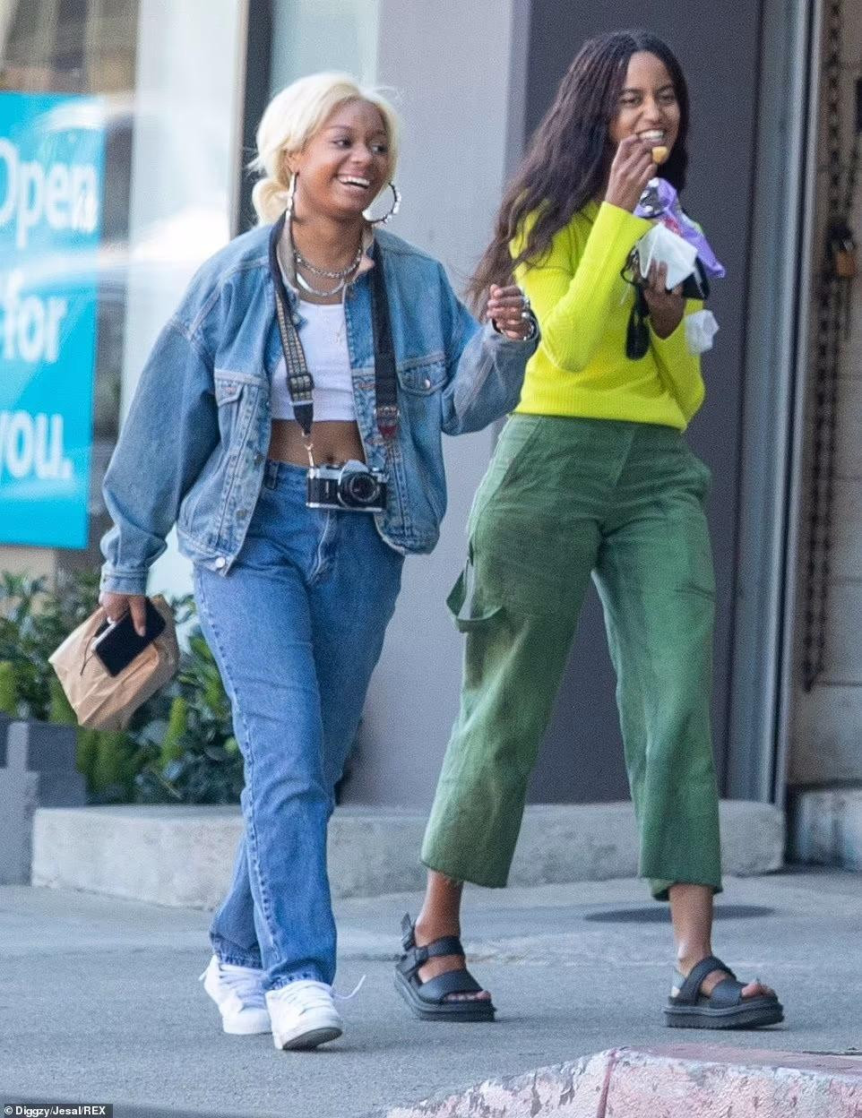 Malia giữ gương mặt nghiêm trọng cho đến khi gặp bạn. Hai cô gái cười đùa rất vui vẻ trên phố.