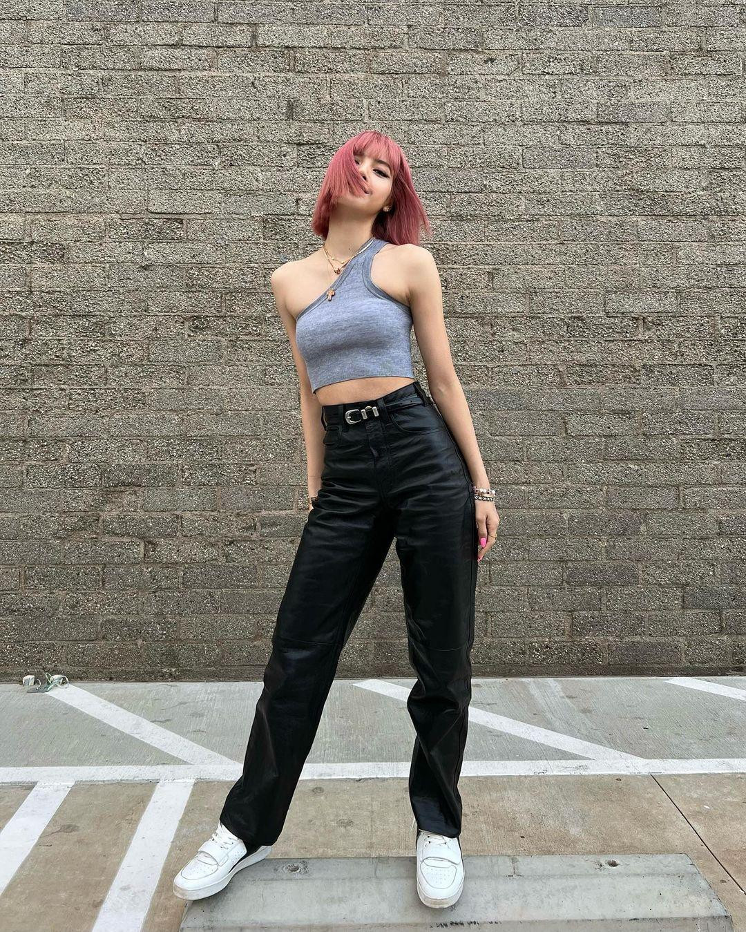 Kiểu phối đồ quen thuộc của Lisa là áo crop-top bó sát kết hợp quần dài thụng và giày thể thao.