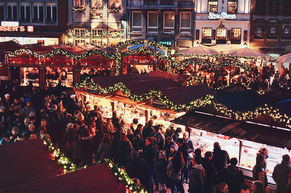 Không khí sôi động trong chợ Giáng sinh ở Aachen vào buổi tối với dòng người tấp nập.