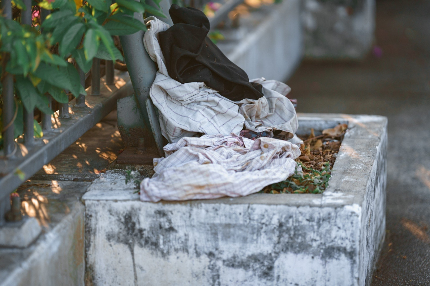 Rác rưởi, chai lọ, quần áo rách vương vãi trên thành cầu. Rác rưởi, chai lọ, quần áo rách vương vãi trên thành cầu.