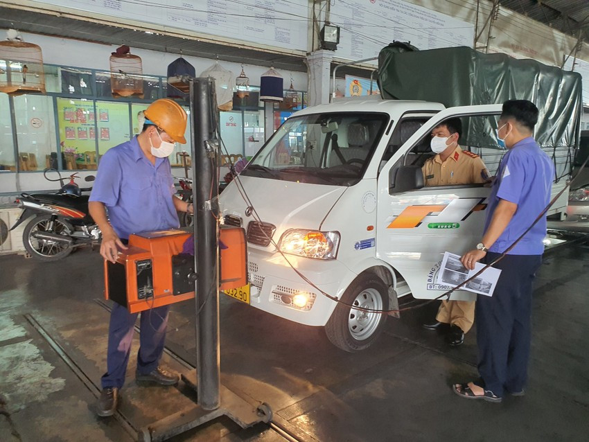 CSGT Nguyễn Tấn Quốc đang hỗ trợ đo độ sáng của đèn xe. Ảnh: Thy Nhung.