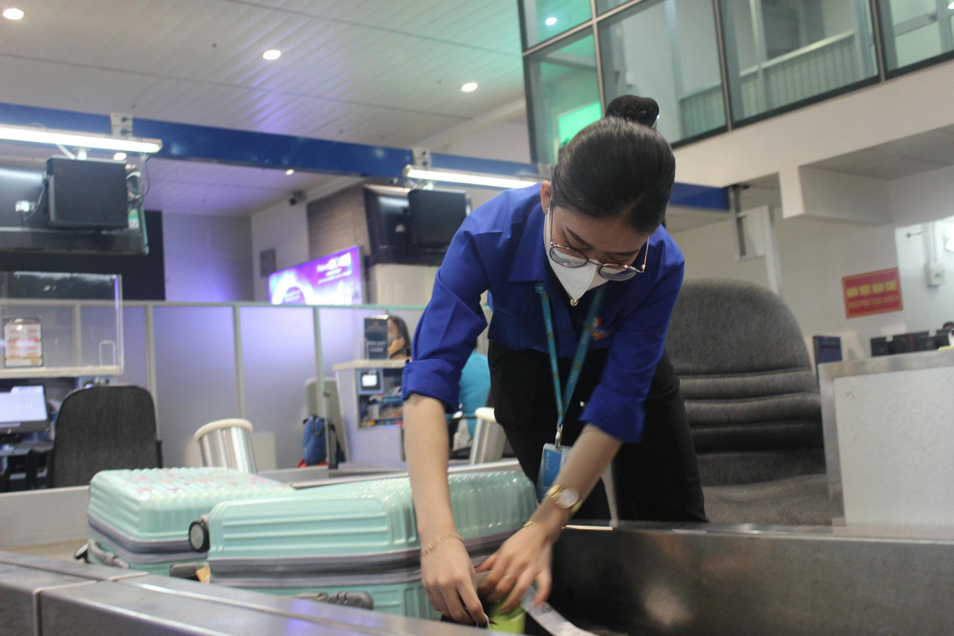 Nhân viên Hãng hàng không Vietnam Airlines trong trang phục áo Đoàn hỗ trợ đại biểu nhanh chóng làm thủ tục và gửi đồ tại quầy check-in.